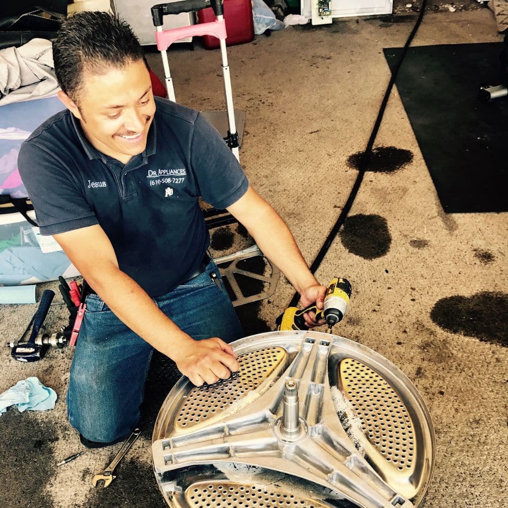 One of Dr. Appliances technicians performs holds the drum during a dryer repair.
